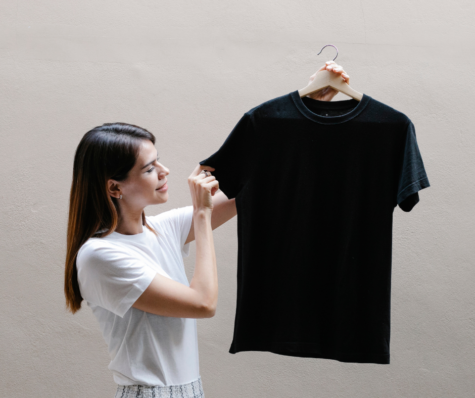 Donna che tiene in mano una maglietta nera personalizzabile